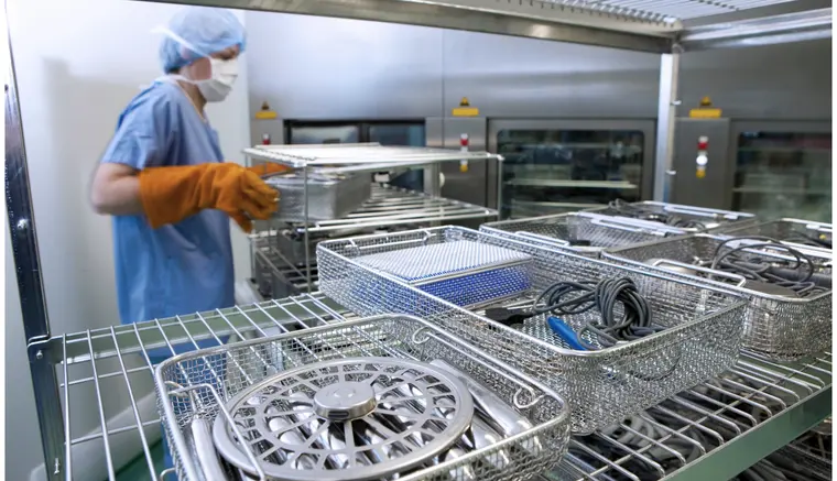 Sterile processing technician handling instrument trays