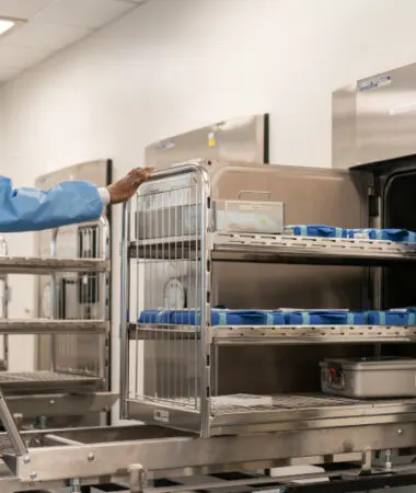 Sterile processing technician loading instrument trays into a washer